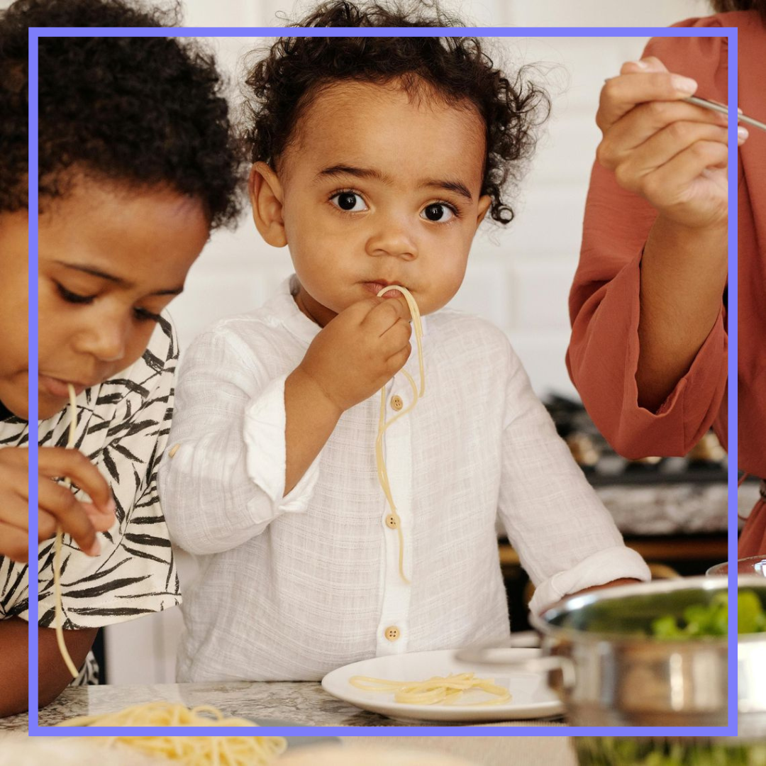 young boys eating pasta